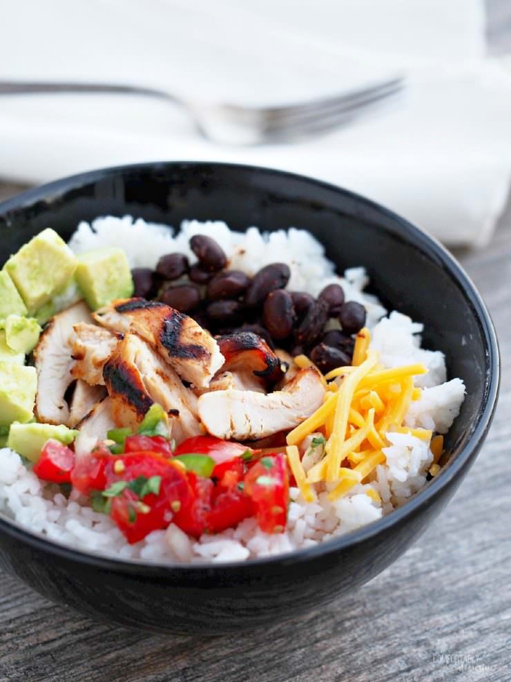 Chicken-Burrito-Bowls nestle perfectly seasoned chicken atop a bed of fluffy lime-cilantro rice along with roasted black beans and all the trimmings for a healthy dinner with loads of flavor. A copy cat recipe of the Chipotle restaurant favorite.