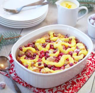 Cranberry-Orange-Bread Pudding is a simple, classic dessert all dressed up with fresh cranberries and a hint of orange for the holidays! Topped with a simple orange custard sauce, Cranberry Orange Bread Pudding is proof that leftover bread can easily be transformed into a delicious dessert.