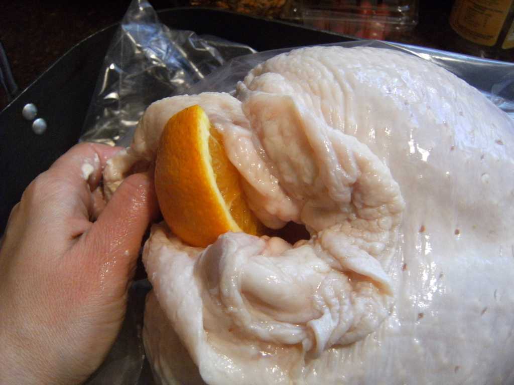 placing aromatics into a turkey chest cavity for roasted turkey