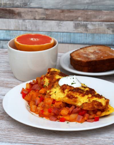 Farmer’s-Omelet wraps diced sweet red peppers, sweet onion, hash browns, Canadian bacon, and cheese in fluffy eggs for a hearty breakfast with serious staying power to keep you going all morning long.