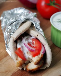 Grilled Chicken Gyros - Tender, souvlaki-style grilled chicken topped with a flavorful garlic, dill, and cucumber tzatziki yogurt sauce, ripe tomatoes, and thinly shaved red onion wrapped in warm pita bread. | ComfortablyDomestic.com