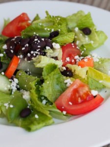 Black beans, crisp greens, fresh vegetables, and Cotija cheese, brightly dressed in a simple lemon vinaigrette. This is a delicious healthy salad recipe!