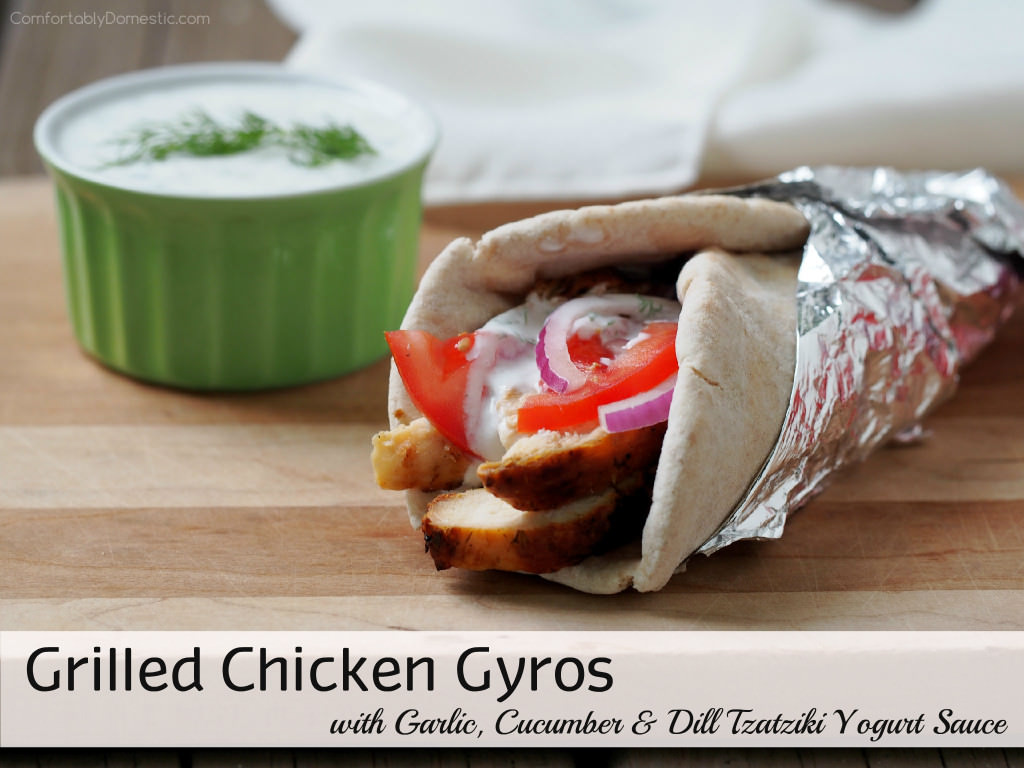 Grilled-Chicken-Gyros - Tender, souvlaki-style grilled chicken topped with a flavorful garlic, dill, and cucumber tzatziki yogurt sauce, ripe tomatoes, and thinly shaved red onion wrapped in warm pita bread. | ComfortablyDomestic.com