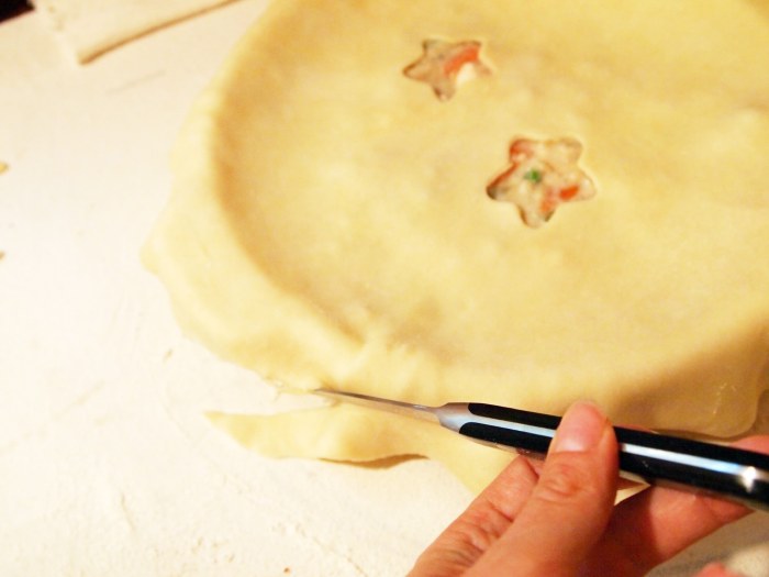 trimming the edges of a chicken pot pie